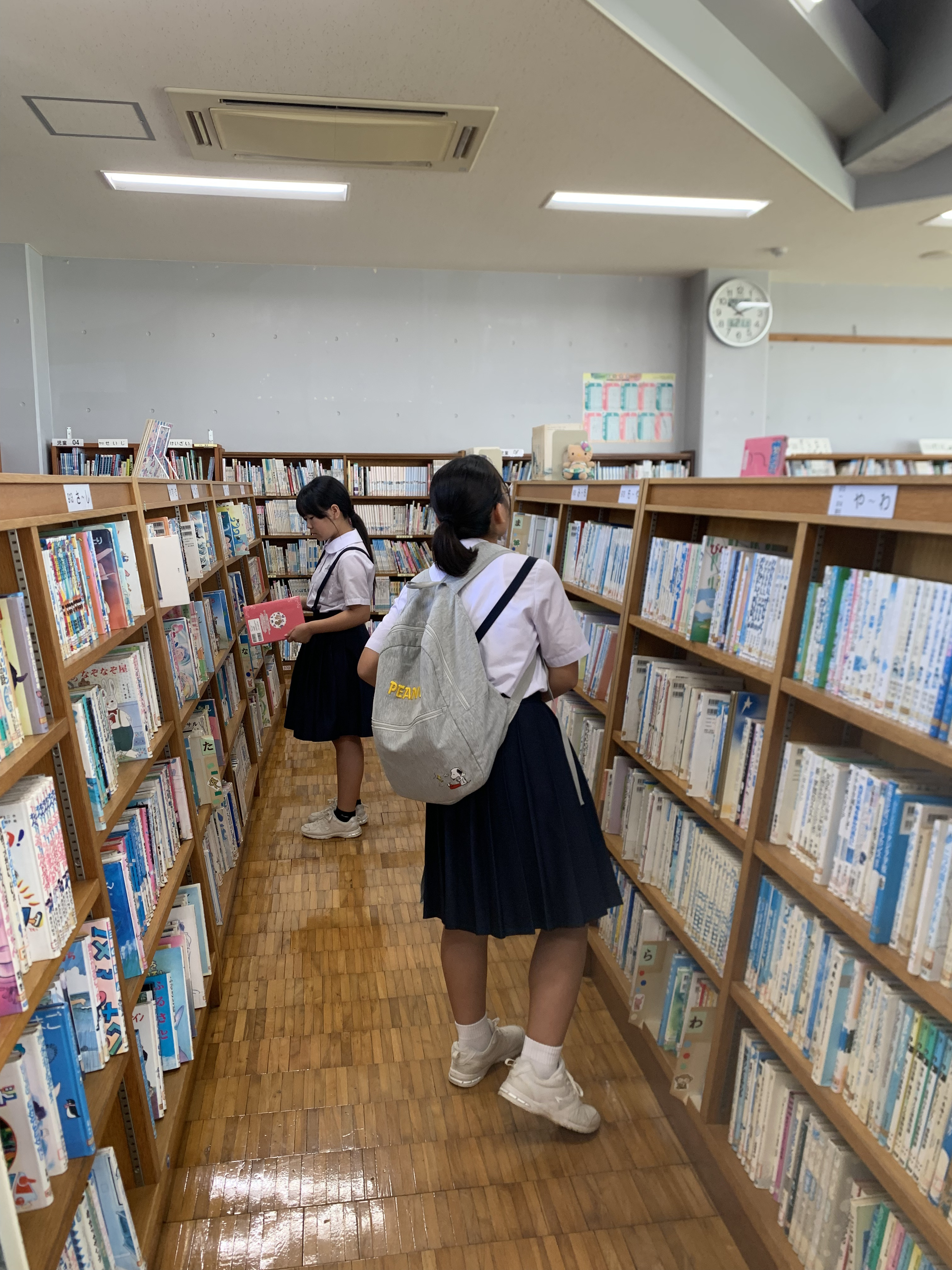 分類ラベルを見ながら返本作業に苦戦する生徒たち